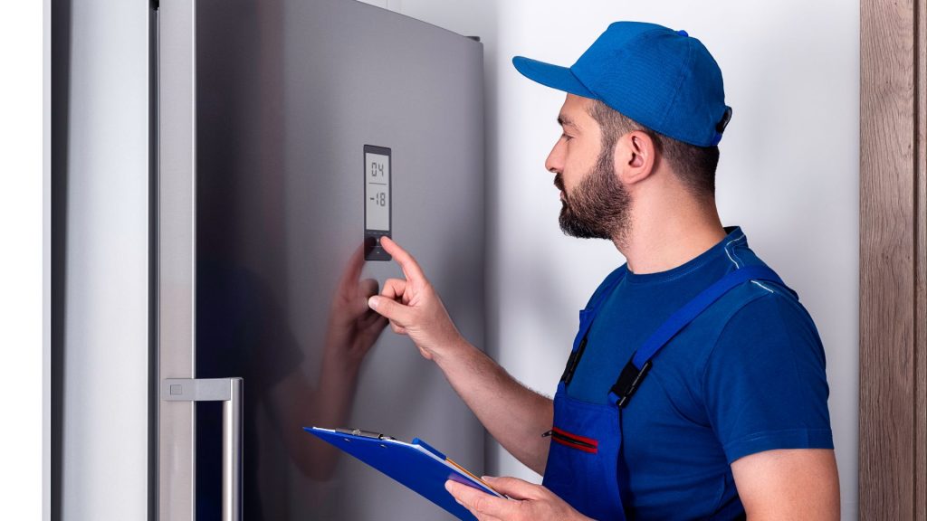 A technician fixes a refrigerator not cooling. 